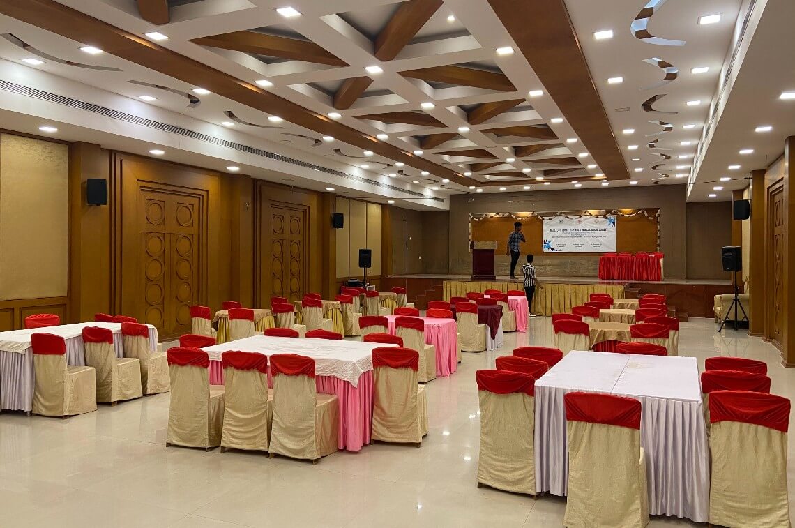 Indoor conference hall with red and white chairs.