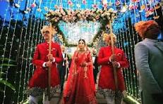 Bride and groom walking on wedding stage with decorations.